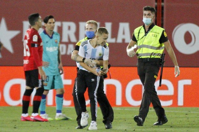 Pitch invader di laga Mallorca vs Barcelona diamankan petugas keamanan. (c) AP Photo