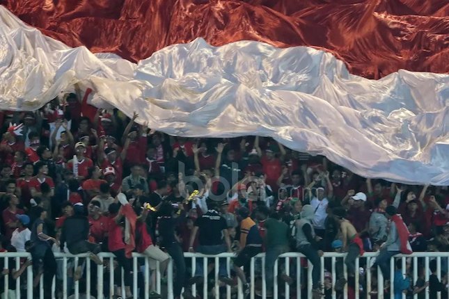 Aksi suporter Timnas Indonesia membentangkan bendera merah-putih raksasa (c) Bola.com/Nicklas Hanoatubun