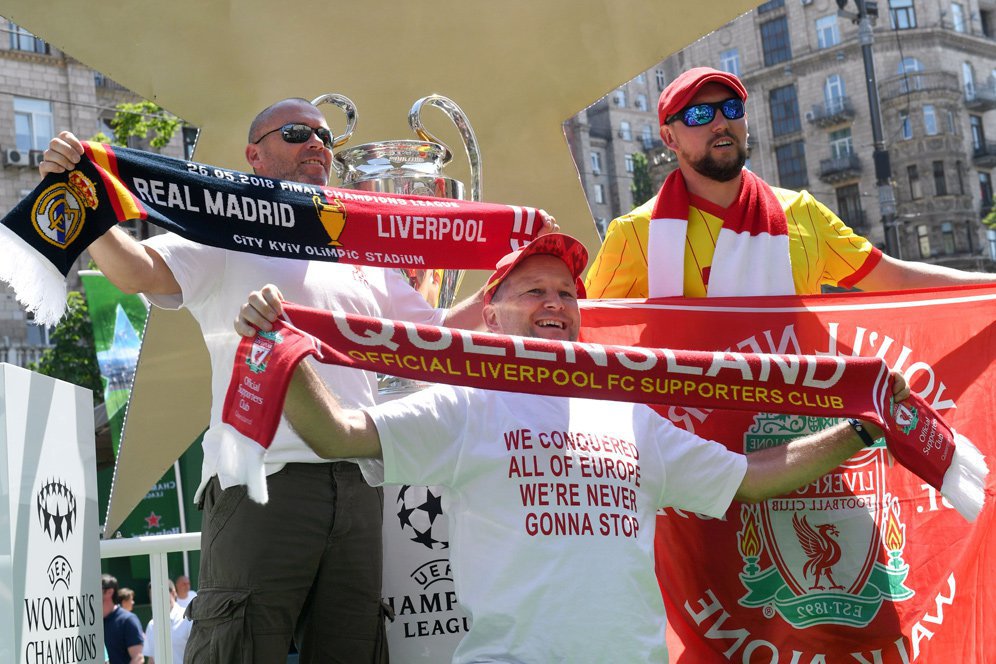 Fans Liverpool berpose bersama trofi Liga Champions.