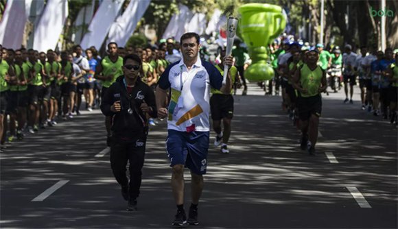 Pevoli legendaris Indonesia, Pascal Wilmar, menyerahkan obor Asian Games XVIII saat melintas di Denpasar, Bali, Selasa.