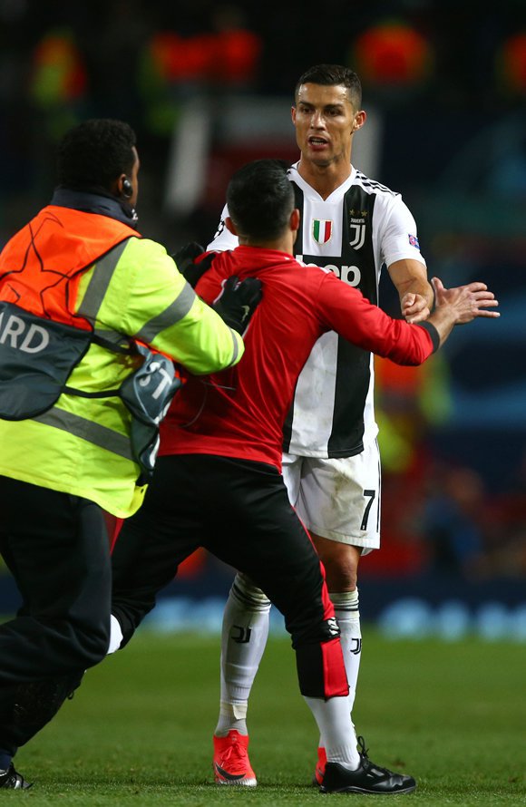 Seorang pitch invader mendekati Cristiano Ronaldo. (c) AP Photo