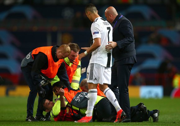 Cristiano Ronaldo melihat seorang pitch invader yang diamankan petugas. (c) AP Photo