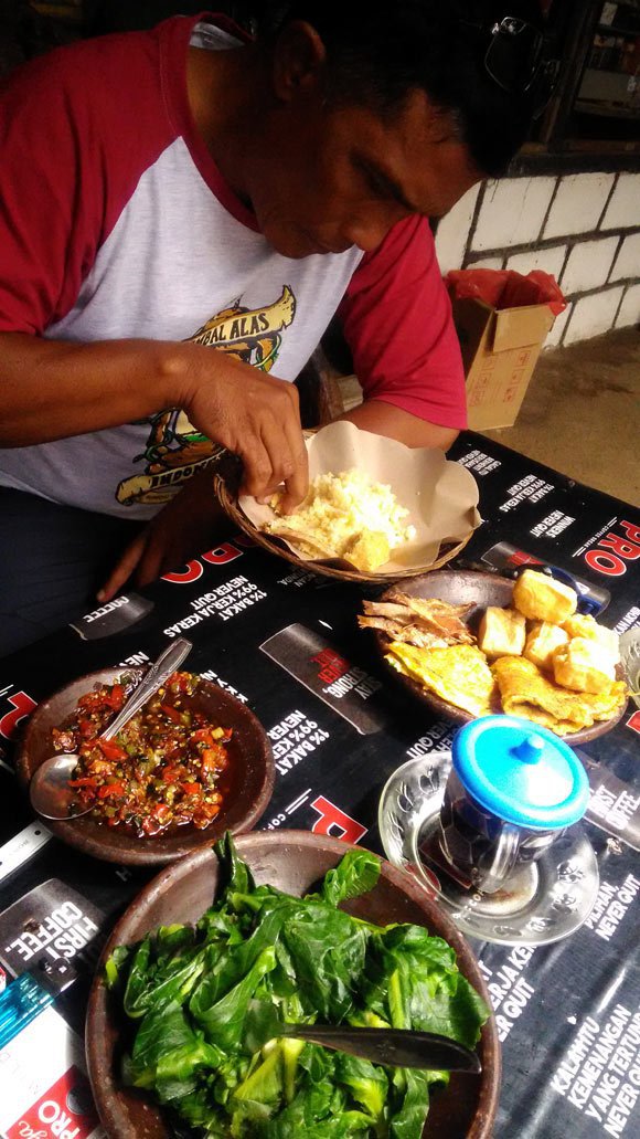 Pak Begal menikmati kuliner khas penduduk Tengger. (c) Dendy Gandakusumah