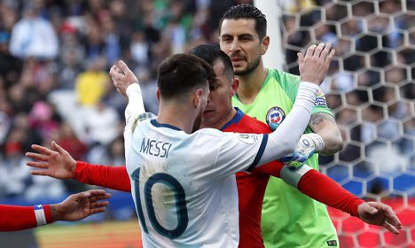 Medel mulai menanduk kepala Messi dan mendorong dadanya. Messi tetap mengangkat tangan, tetapi sikapnya dianggap memprovokasi. (c) AP Photo