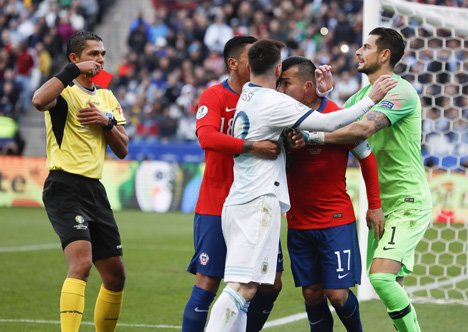 Wasit Mario Diaz de Vivar berlari mendatangi lokasi insiden dan langsung mengeluarkan kartu merah. Kedua pemain masih terlibat konfrontasi. (c) AP Photo