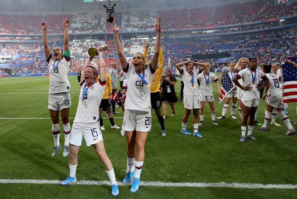 Megan Rapinoe (15) berselebrasi dengan rekan setimnya dengan mengangkat trofi Piala Dunia Wanita 2019. (c) AP Photo