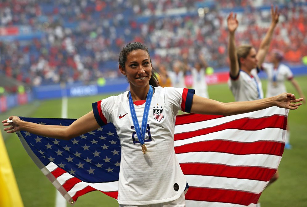 Pemain Amerika Serikat, Christen Press memegang bendera Amerika usai pastikan diri jadi juara dunia 2019. (c) AP Photo