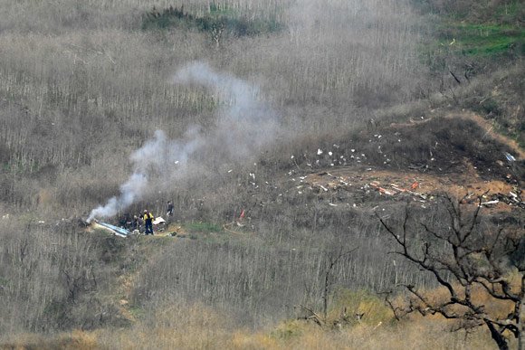 Puing-puing helikopter tampak berserakan di sekitar area kejadian. (c) AP Photo