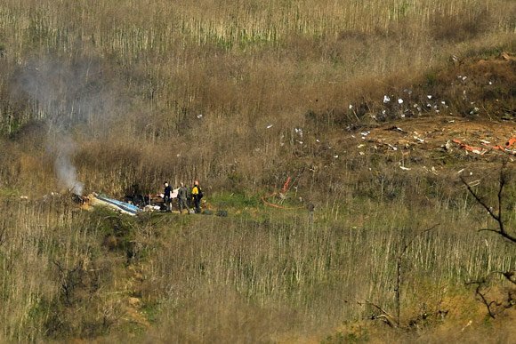 Asap dari helikopter yang terbakar sudah mulai menipis seiring kedatangan tim evakuasi. (c) AP Photo