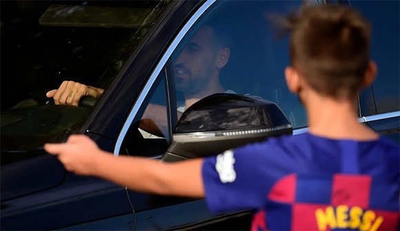 Seorang fan cilik Lionel Messi menunggu idolanya di pintu masuk tempat latihan Barcelona. Namun sayang, keinginannya bertemu sang idola harus gagal karena Messi memilih absen. (c) AFP/Paul Barrena