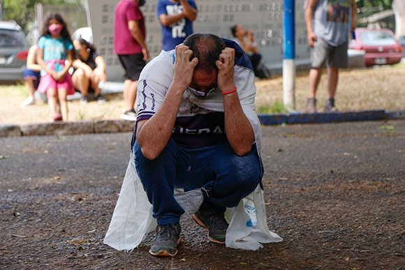 Seorang fans sepak bola tertunduk sedih di luar stadion Gimnasia, La Plata, Argentina, setelah kabar meninggalnya Diego Maradona tersiar. (c) AP Photo
