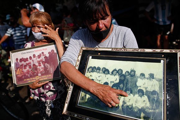 Tetangga Maradona di Villa Fiorito, tempat sang legenda lahir, menunjukkan foto ketika sang legenda masih bermain di sebuah klub lokal daerah asalnya. (c) AP Photo