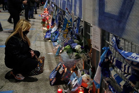 Fans Napoli berkumpul di luar stadion San Paolo untuk memberikan penghormatan terakhir pada pahlawan klub yang meninggal dunia akibat serangan jantung, Rabu (25/11/2020) malam WIB. (c) AP Photo
