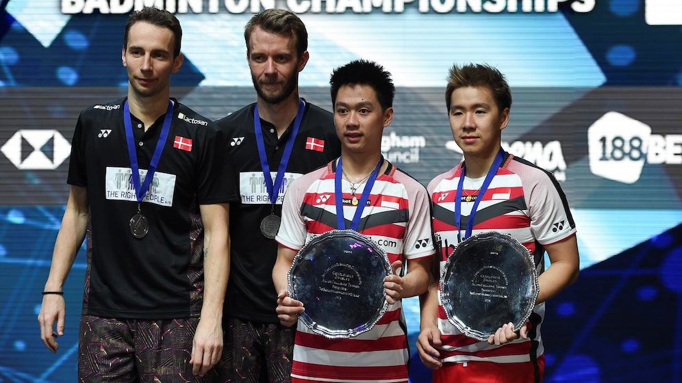 Ganda putra Indonesia, Kevin Sanjaya (kedua kanan) dan Marcus Fernaldi (kanan) berpose sambil memegang piala usai mengalahkan pebulutangkis Denmark Mathias Boe dan Carsten Mogensen di final All England, Birmingham, Inggris (18/3). (c) AFP Photo/Paul Ellis