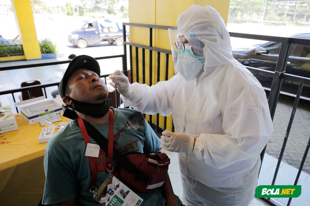 Seorang wartawan sedang melakukan swab antigen sebelum memasuki Stadion Kanjuruhan, Malang, jelang pertandingan sepak bola Piala Menpora 2021, Senin (22/3/2021). (c) Bola.net/Arief Bagus