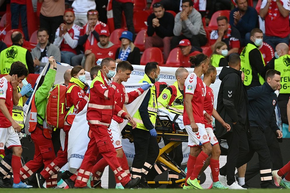 Pemain Denmark dan tim medis berjalan keluar lapangan menuju kamar ganti setelah Christian Eriksen mendapatkan pertolongan pertama. (c) AP Photo