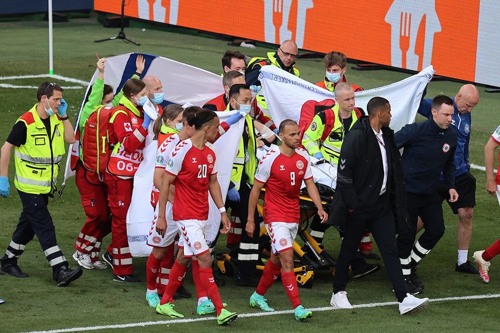 Tim medis membawa Christian Eriksen dengan menggunakan alat bantu menuju ke ruang ganti pemain. (c) AP Photo