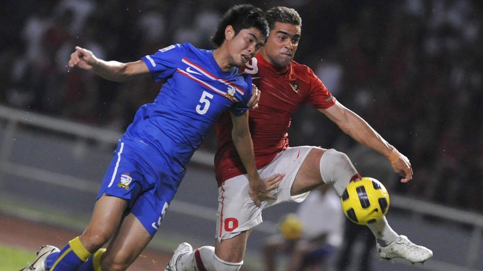 Penyerang Timnas Indonesia, Cristian Gonzales, berduel dengan Suttinun Phukham pada laga Piala AFF 2010. (c) AFP/Romeo Gacad
