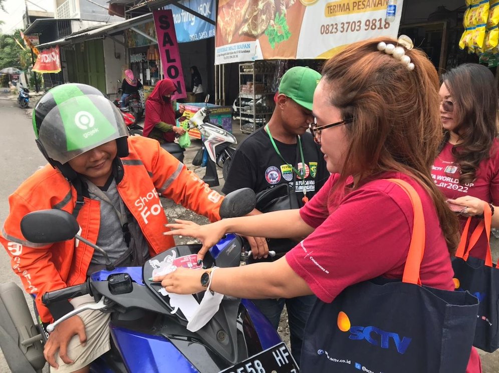 Di Gresik, tim SCM juga membagi-bagikan sticker Piala Dunia 2022 kepada para pengunjung dan juga para ojek online (c) SCM