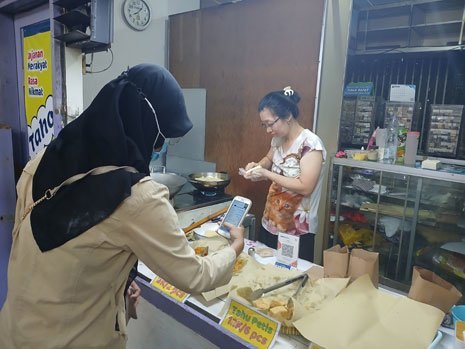 Wilda Fizriyani ketika membayar dengan aplikasi BRImo di acara Festival Jajanan Pasar Malang (c) Asad Arifin