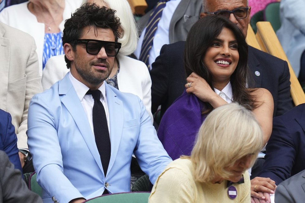 Aktor Inggris, Dominic Cooper (kiri) duduk bersebelahan dengan aktris India, Priyanka Chopra di Royal Box di Centre Court Wimbledon Tennis Championships, London. (c) AP Photo/Kirsty Wigglesworth