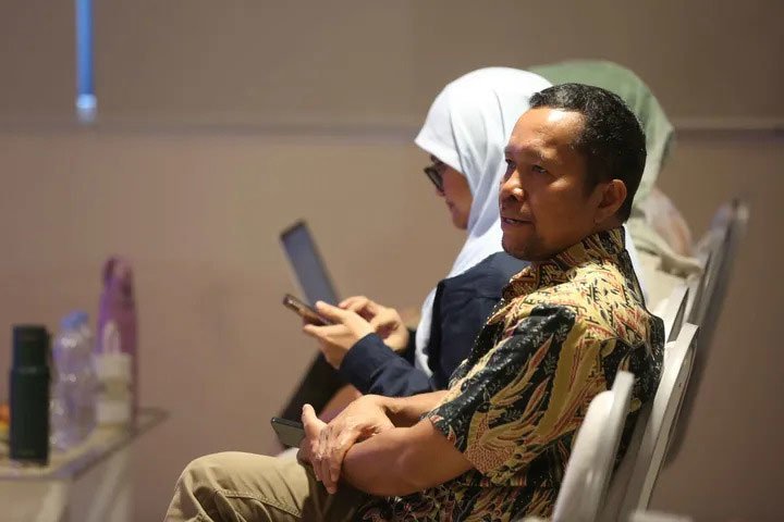 Chief Content Officer Kapanlagi Youniverse, Wenseslaus Manggut menyaksikan presentasi seminar Upstream Force We Are The Energy di Auditorium Lantai 2 Gedung IDE FTUI, Selasa (4/11/2025) (c) Liputan6.com/Helmi Fithriansyah