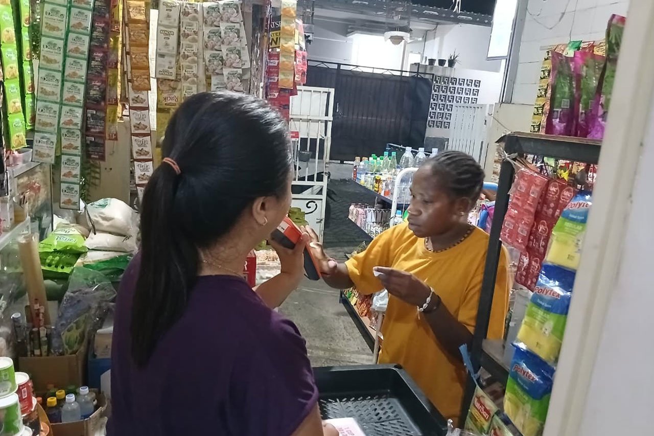 Yesi Kristiningsih, Agen BRILink di Malang, saat sedang melayani warga yang melakukan transaksi (c) Asad Arifin