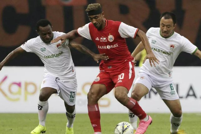 Dua pemain Kalteng Putra, Ferinando Pahabol dan Yu Hyunkoo berusaha untuk merebut bola dari penguasaan gelandang Persija, Bruno Matos di laga perempat final Piala Presiden 2019, di Stadion Patriot Candrabhaga, Bekasi, Kamis (28/03). (c) Bola.com/Yoppy Renata