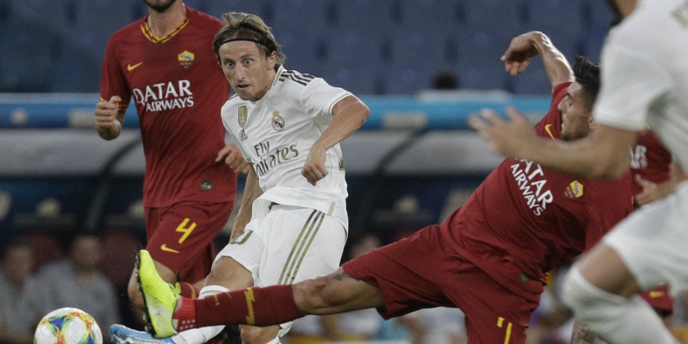 Gelandang Real Madrid Luka Modric mengoper bola meski diganggu oleh gelandang AS Roma, Lorenzo Pellegrini. (c) AP Photo