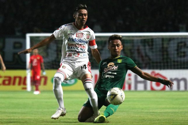 Fadil Sausu berduel melawan Osvaldo Haay di pertandingan Persebaya Surabaya vs Bali United, Selasa (24/09/2019). (c) Bola.com/Aditya Wany