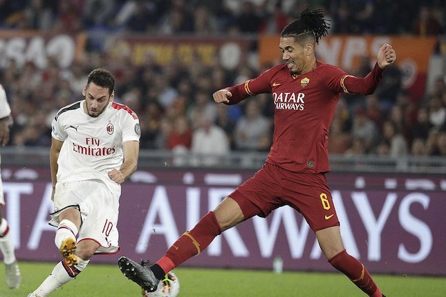 Bek AS Roma, Chris Smalling, berupaya memblokade tembakan dari pemain AC Milan, Hakan Calhanoglu. (c) AP Photo
