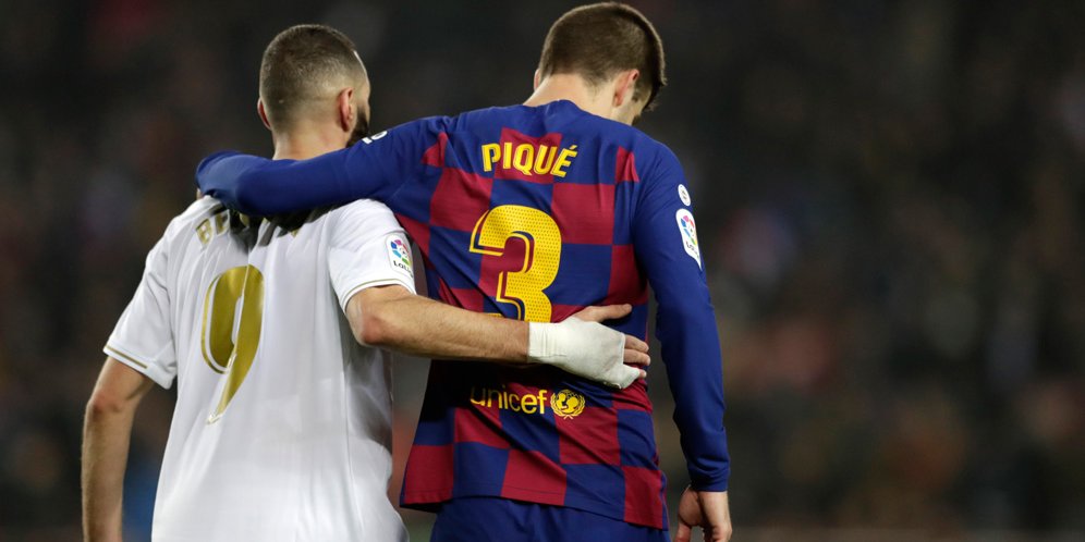 Bomber Real Madrid, Karim Benzema, bersama bek senior Barcelona, Gerard Pique usai duel El Clasico. (c) AP Photo