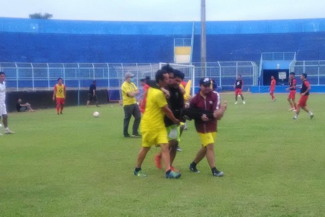 Kurniawan Kartika Ajie harus dibopong keluar lapangan setelah mengalami cedera di sesi latihan Arema FC, Senin (3/8/2020) (c) Bola.net/Dendy Gandakusumah