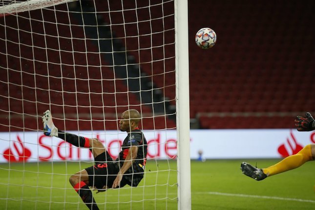 Aksi Fabinho saat menghalau bola sundulan Dusan Tadic yang akan masuk ke gawang Liverpool di laga lawan Ajax Amsterdam di matchday 1 Liga Champions 2020-21, Kamis (22/10/2020). (c) AP Photo