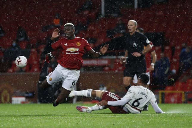 Gabriel Magalhaes melakukan tekel kepada Paul Pogba di laga Manchester United vs Arsenal (c) AP Photo