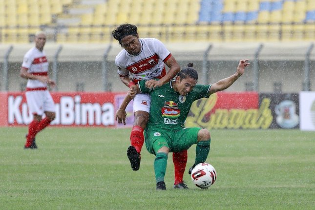 Pemain PSS Sleman, Kim Jeffrey Kurniawan, berebut bola dengan pemain Madura United, Rendika Rama, di pada laga Piala Menpora 2021 di Stadion Si Jala Harupat, Bandung, Selasa (23/3/2021).  (c) Bola.net/M Iqbal Ichsan