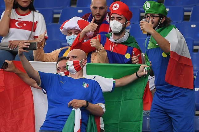 Fans Italia berpose sebelum memberikan dukungan pada Azzurri saat melawan Turki di laga pertama Grup A Euro 2020. (c) AP Photo