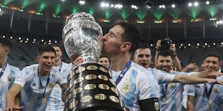 Lionel Messi mencium trofi Copa America 2021 (c) AP Photo