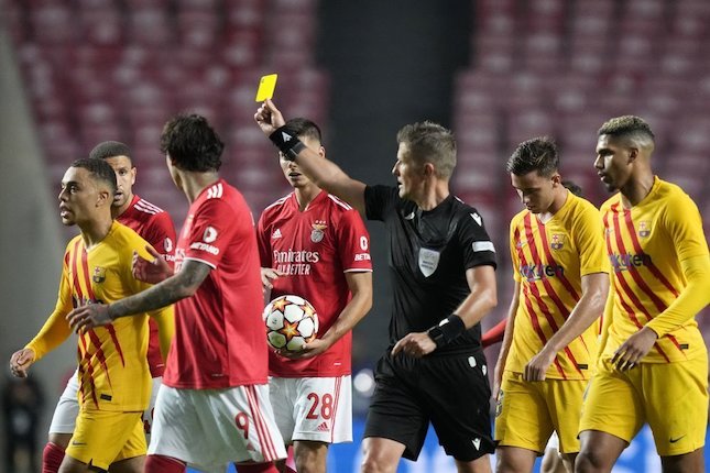 Wasit memberikan kartu kuning pada pemain Barcelona pada duel melawan Benfica di matchday kedua Liga Champions 2021/2022 (c) AP Photo