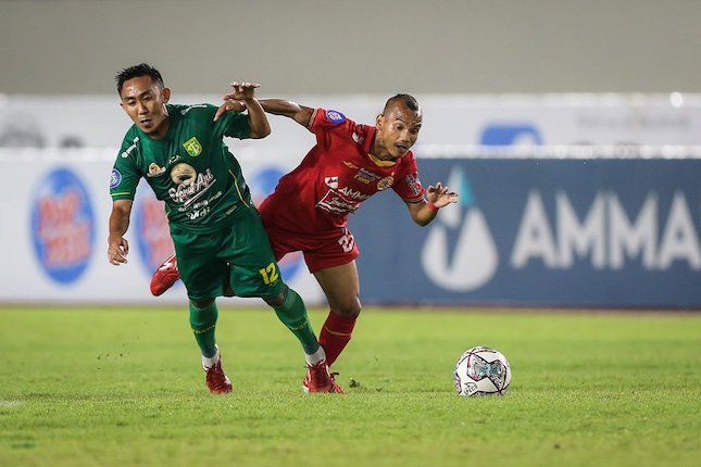 Pemain Persebaya Surabaya, Rendi Irawan Saputra (kiri) dan pemain Persija Jakarta, Riko Simanjuntak berebut bola saat laga pekan 9 BRI Liga 1 2021/2022. (c) Bola.net/Bagaskara Lazuardi