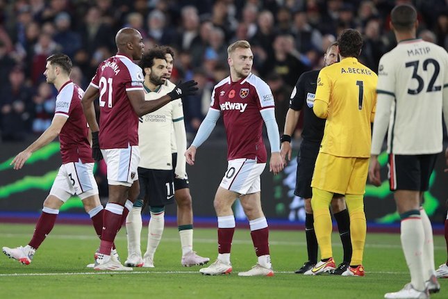 Alisson Becker berusaha memprotes keputusan wasit di laga West Ham vs Liverpool di London Stadium, Minggu (07/11/2021) malam WIB. (c) AP Photo