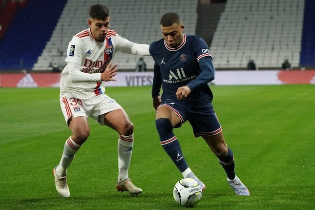 Aksi Bruno Guimaraes menempel Kylian Mbappe dalam laga Lyon vs PSG, Senin (10/1/2022) (c) AP Photo