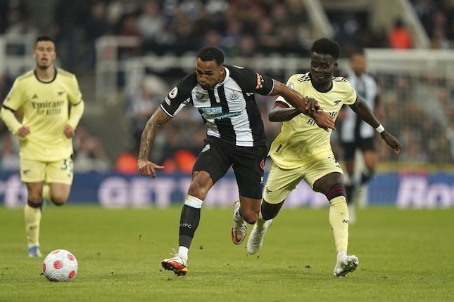 Bukayo Saka (kanan) berebut bola lawan Callum Wilson di laga Newcastle vs Arsenal di St James Park, Selasa (17/05/2022) dini hari WIB. (c) Pa via AP Photo