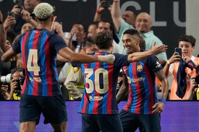 Pemain Barcelona Raphinha melakukan selebrasi setelah mencetak gol ke gawang Real Madrid, Minggu (24/7/2022). (c) AP Photo