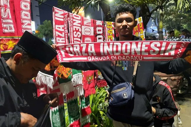 Para penjual atribut seputar Timnas Indonesia U-19 mendapatkan berkah atas kehadiran suporter yang sudah diperbolehkan kembali ke stadion pada Piala AFF U-19 2022 (c) Bola.com/Zulfirdaus Harahap