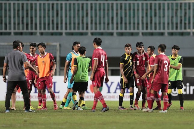 Dua pemain Malaysia U-17 coba menghibur striker Indonesia U-17, Arkhan Kaka (empat dari kanan), yang menangis usai laga Indonesia vs Malaysia di Stadion Pakansari, Minggu (09/10/2022) malam WIB berakhir. (c) Bola.net/Ikhwan Yanuar