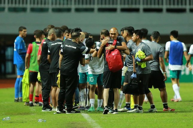 Para pemain dan staf pelatih Indonesia U-17 dan Palestina U-17 saling bersalaman dan berpelukan usai bertanding di Stadion Pakansari, Bogor, Jumat (07/10/2022) malam WIB. (c) Bola.net/M. Iqbal Ichsan