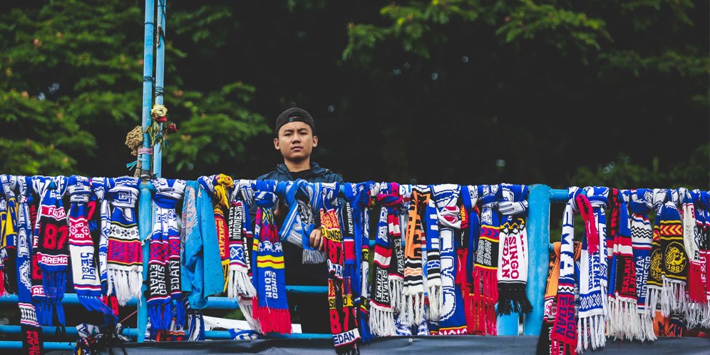 Aremania Blimbingan, Kota Malang, Sindu Dwi Asmoro, berdiri di jembatan tempat menggantung syal-syal, tanda gerakan berhenti menonton sepak bola setelah tragedi Kanjuruhan pada 1 Oktober 2022 yang menelan 132 korban meninggal. Foto diambil Sabtu (8/10/2022). (c) Bola.net/Bagaskara Lazuardi
