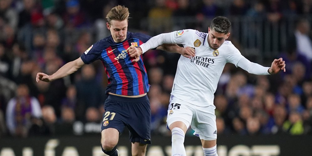 Duel Frenkie de Jong dan Federico Valverde dalam laga Barcelona vs Real Madrid pada pekan ke-26 La Liga 2022/2023 di Spotify Camp Nou, Senin (20/03/2023) dini hari WIB. (c) AP Photo/Joan Mateu