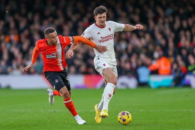 Harry Maguire dikawal Carlton Morris di laga Luton Town vs Manchester United pada Premier League 2023/2024, Minggu (18/2/2024) malam WIB.  (c) AP Photo/Ian Walton